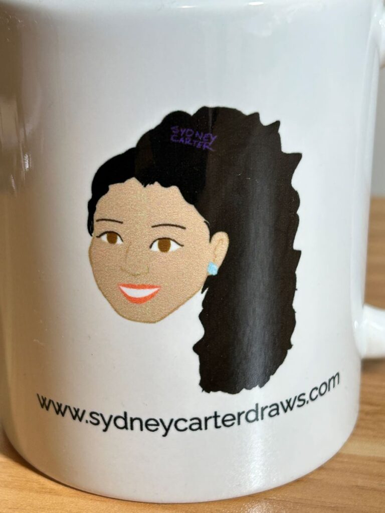Mug with Sydney Carter cartoon and website close-up view